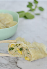 Close up inside a steamed Korean dumpling Mandu on a marble kitchen counter