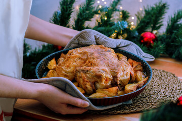 The woman hands sets the table, serves dinner. Christmas dinner, a festive dish. Side view of the table, close-up. Selective focus