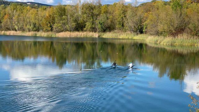 Two canoe pirogue crossing a calm lake with turquoise water in Banyoles Girona Costa Brava of Spain