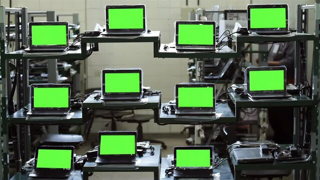 Laptops Green Screens inside a Computer Factory. You can replace green screen with the footage or picture you want with “Keying” effect in After Effects (check out tutorials). 4K Resolution.