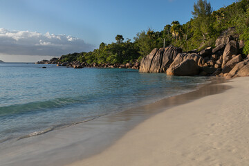 Obraz premium Pacifying seascape of Lazio beach on the island of Praslin in the Seychelles. Perfect sandy coastline is washed by the turquoise waters of the Indian Ocean. The blue lagoon is guarded with huge rocks