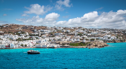 Fototapeta premium Panoramic landscape with town and windmills along coastline on Mykonos Island, Greece.