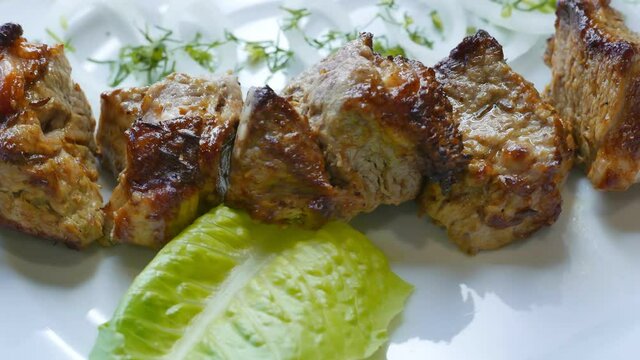 Tasty beef shish kebab barbecue on a plate ready for dinner. Grilled meat rotating