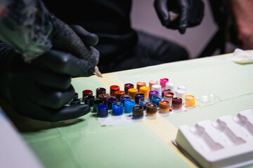 Close-up of tattoo artist work place parts and paint, machines and other equipment. Professional...