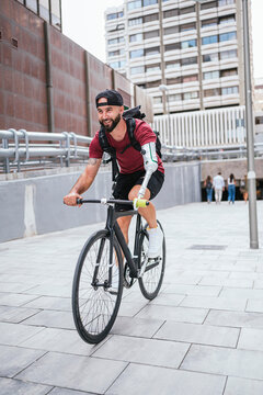 Man with bionic arm riding bike in city