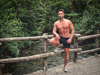 Handsome Muscular Shirtless Hunk Man Outdoor in Country Leaning Against Fence