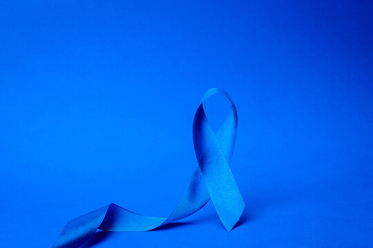 Prostate awareness. Awareness of men health in November with blue prostate cancer ribbon isolated on deep blue background. Healthcare, International men, Father day.