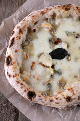Napolitan pizza 4 cheese on paper on an old wooden table