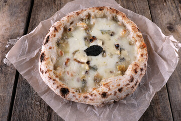 Napolitan pizza 4 cheese on paper on an old wooden table