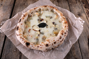 Napolitan pizza 4 cheese on paper on an old wooden table