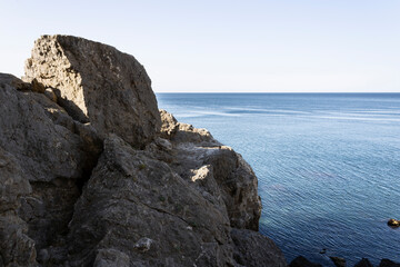 sea bay at the foot of the mountains against the blue sky on a summer day