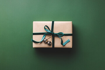 Christmas gift box tied velvet ribbon on green background.