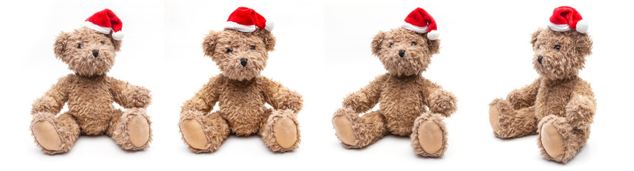 Vier Teddybären mit Weihnachtsmütze sitzend auf weißem Hintergrund