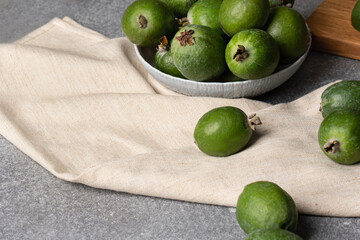bowl with green feijoa berries on gray table.Acca sellowiana for detox smoothie ingredients, healthy food concept