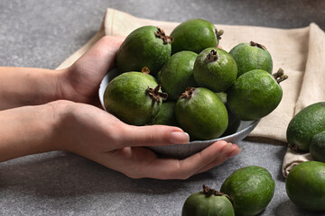 female hands holding bowl of green feijoa berries.Vitamins and healthy nutrition concept with acca sellowiana
