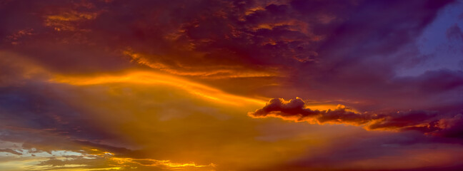 Obraz premium The rays of the setting sun creating red and yellow hues on the underside of a late day storm during the Arizona Monsoon season of 2014.