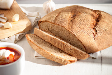 Rye homemade bread with traditional ukrainian red soup borscht.