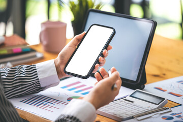 Cropped image of a female freelance translator's hand. holding a blank screen smartphone in his modern workplace