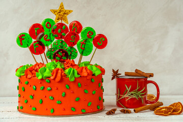 Christmas cake with balls with an inscription in German Frohes Fest Happy holidaya cup of tea with cinnamon and star anise. Decoration for the holiday. Beautifully served table for the celebration.