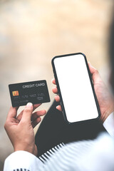 female hand holding phone and credit card