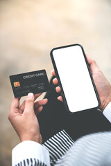 female hand holding phone and credit card
