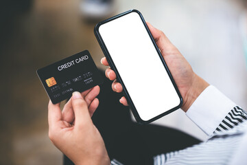 female hand holding phone and credit card