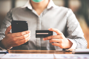 female hand holding phone and credit card