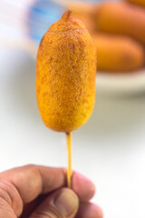 Man holds Corn dogs cooked with sausage and dough - obrazy, fototapety, plakaty