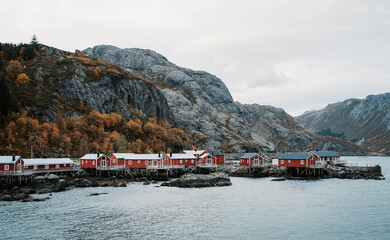 The pretty village of Nusfjord in Lofoten, a fishing village with rows of red wooden houses on top of the sea and rocks. Norway.