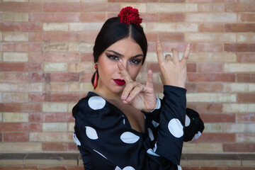 Spanish, beautiful, brunette flamenco dancer in a typical flamenco dress with white polka dots. She...