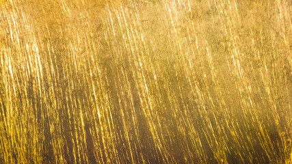The worn, old surface is yellow with dark, vertical stripes. Vintage background.
