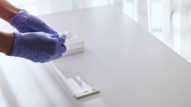 doctor in medical gloves unscrew buffer bottle, press all drops on extraction test tube. SARS-CoV-2 Antigen Rapid Test Kit for in vitro qualitative quick detection of nucleocapsid antigen in oral flui
