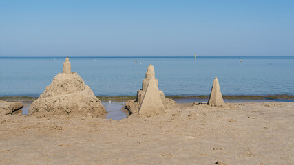 Sandcastles on the beach of Kolobrzeg on the Polish Baltic coast in summer - obrazy, fototapety, plakaty