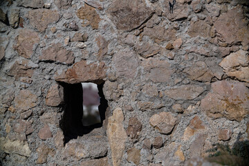 Loopholes in the stone wall of the tower of the ancient fortress