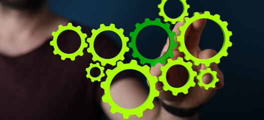 Mechanism, green metallic gears and cogs at work on brown background. Industrial machinery. 3D