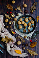 Autumn background flat lay. Walnuts, autumn leaves, berries, anise, acorns, pine cones on a rustic dark wood. Hello Autumn and Happy Thanksgiving. Autumn pattern