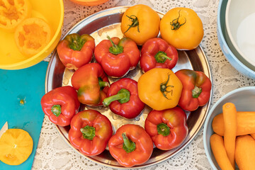 Fototapeta na wymiar Red peppers and yellow tomatoes for cooking on a large plate