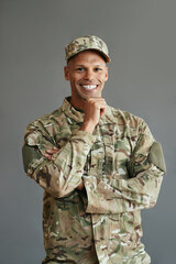 Portrait of happy mixed race military man in camouflage clothing looks at camera.