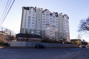 Very high multi-storey residential building. Light green facade of the house