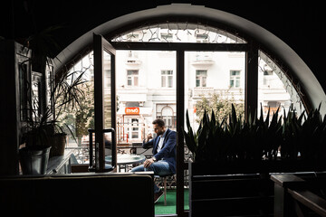 Obraz na płótnie Canvas Man like coffee. Handsome man with cup of coffee in cafe. Morning lifestyle of male. Man is sitting on the summer terrace in cafe, drinking coffee and smiling.