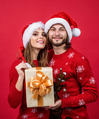 xmas man and woman in knitted sweater and santa hat, christmas sale