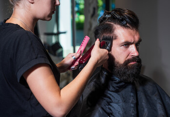 Getting perfect shape of mature bearded guy getting beard haircut by hairdresser at barbershop, Designing new hairdo