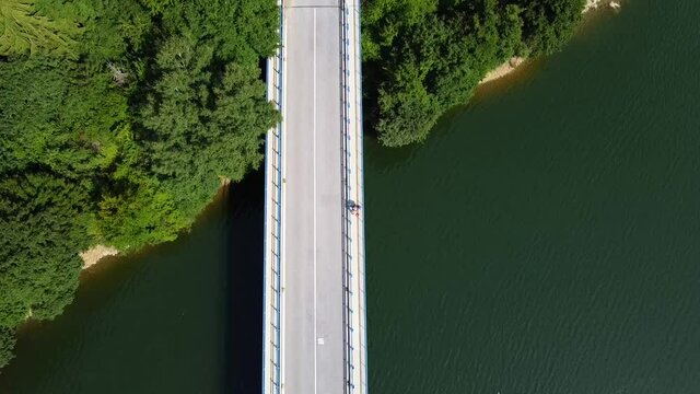 Lake bridge. Cars on th road. View of the Ruzin reservoir on the outskirts of Kosice. River and trees. Drone Video. Top down view. Slovakia. Europe