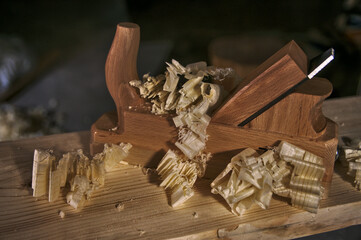 Klasyczny strug ręczny do drewna w otoczeniu strużyn związany z tradycyjnym stolarstwem.