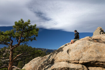 Hiker sitting on a rock, Rocky Mountains, Colorado