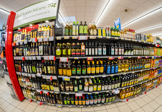 Turin, Italy - November 12, 2021: supermarket shelf with selection and assortment of extra virgin olive oil, fish eye vision