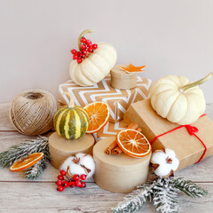 Christmas composition. Christmas gift, white pumpkins, fir branches on a wooden background. Side view, postcard in the form of a square