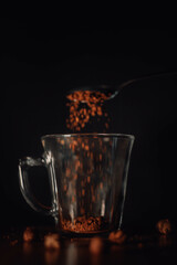 pouring coffee grains in a cup