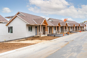 Semi-detached houses in construction in a housing development on a clear autumn day