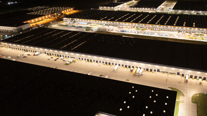 Night aerial view of the warehouse of goods. Logistic center in the industrial area of the city...